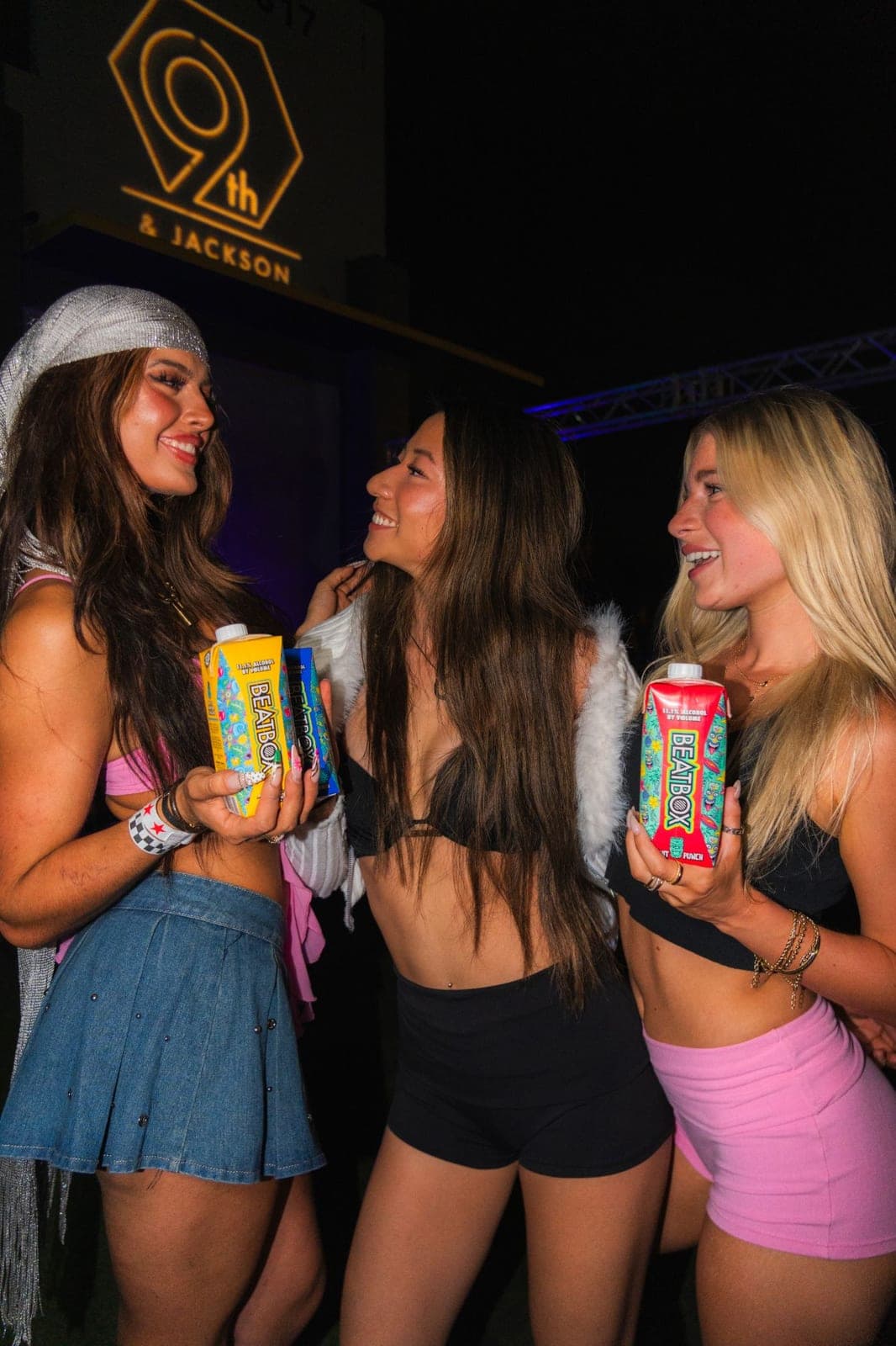 Three attendees holding BEATBOX cartons outside a sponsored venue event